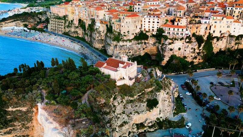 My Summer 10-Day Secret Italy Itinerary: Hidden Beaches & Island Bliss The historic town of Tropea perched on a high cliff overlooking a white sand beach and blue sea, Calabria, Italy